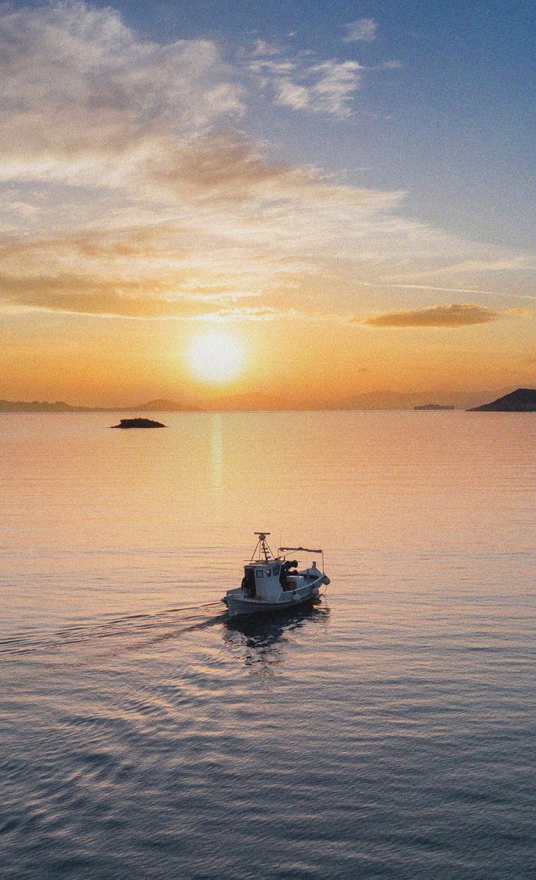 Fishing boat at sunset. Greece. Aerial drone view of typical fis