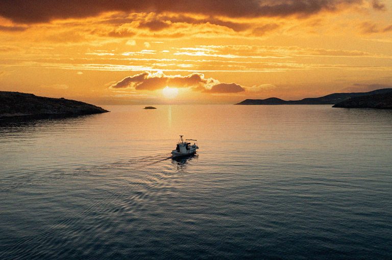 Fishing boat at sunset. Greece. Aerial drone view of typical fis